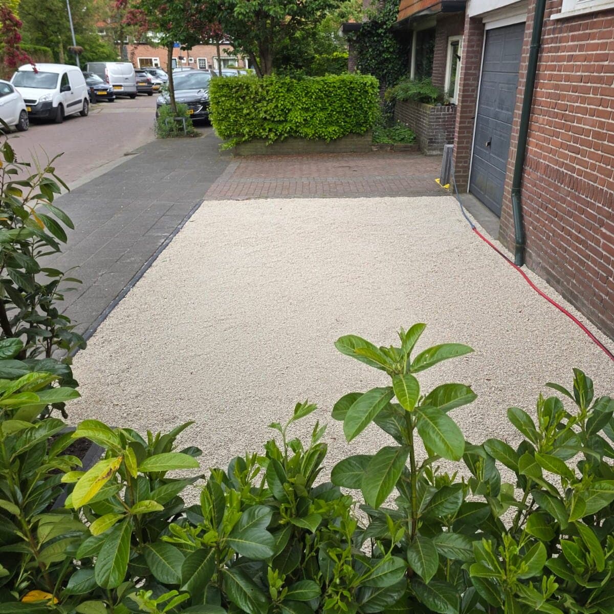Voortuinaanleg met laurierhaag en bestrating